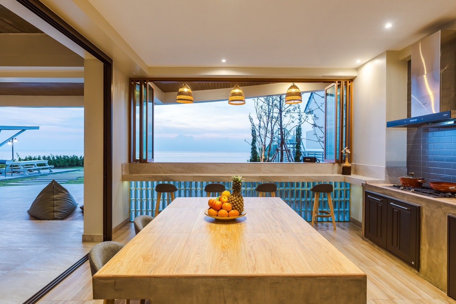 All About VII Pool Villa dining area with ocean view. Indoor-outdoor counter seating and large table for family meals.