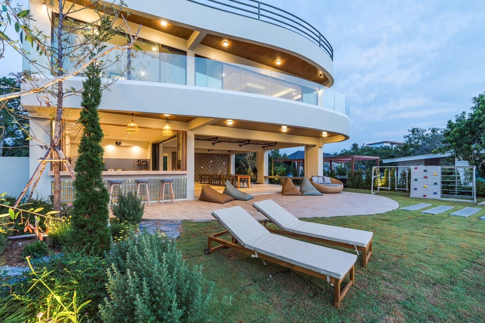 Lounge chairs on the lawn at All About VII Pool Villa, near Bangket Beach, Cha Am. Outdoor bar and dining area visible.