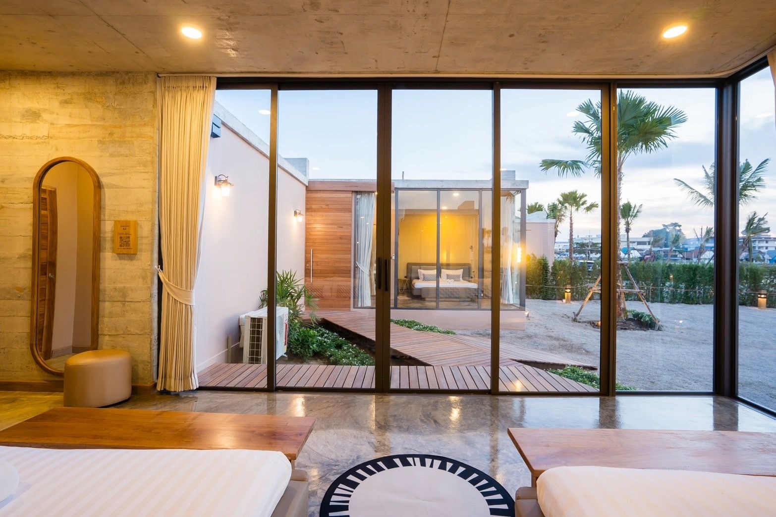 Bedroom view at Amore' A Pool Villa, หาดปึกเตียน-ชะอำ. View through glass doors to exterior walkway and another bedroom.