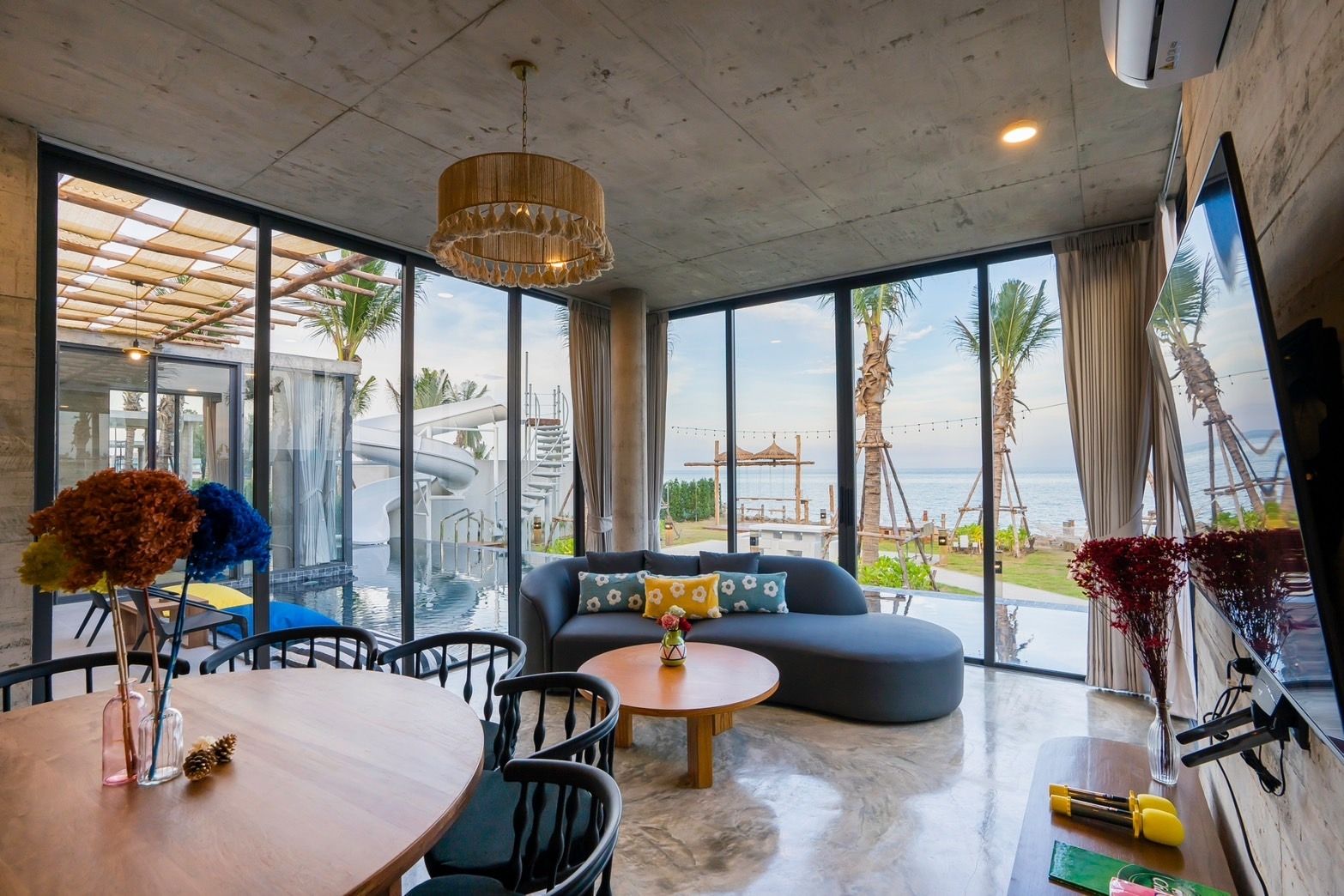 Living room with ocean view at Amore' A Pool Villa, หาดปึกเตียน-ชะอำ. Modern sofa and dining table visible.