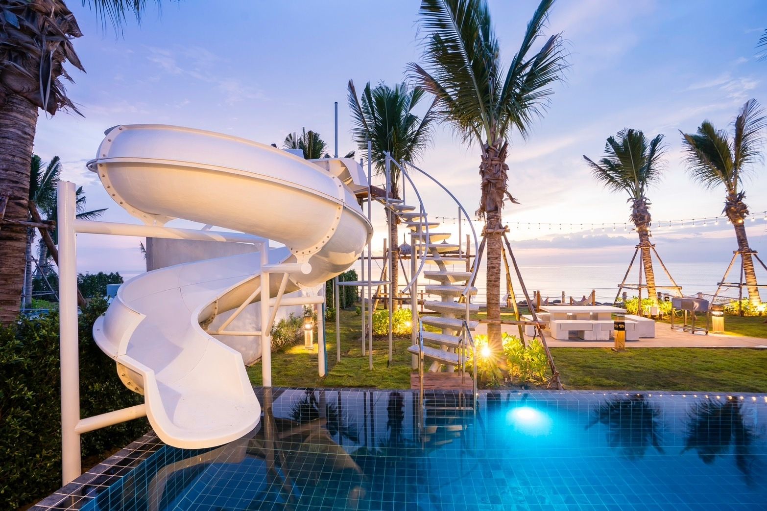Amore' A Pool Villa pool with water slide at sunset, หาดปึกเตียน-ชะอำ. Palm trees and ocean view.