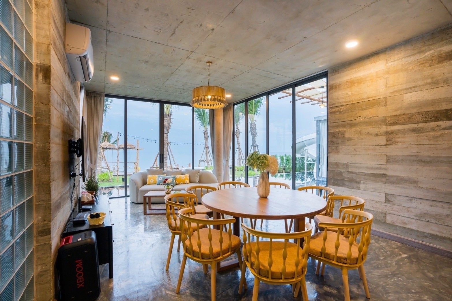 Amore' B Pool Villa Cha-Am dining area with round wooden table and chairs, view to beach.