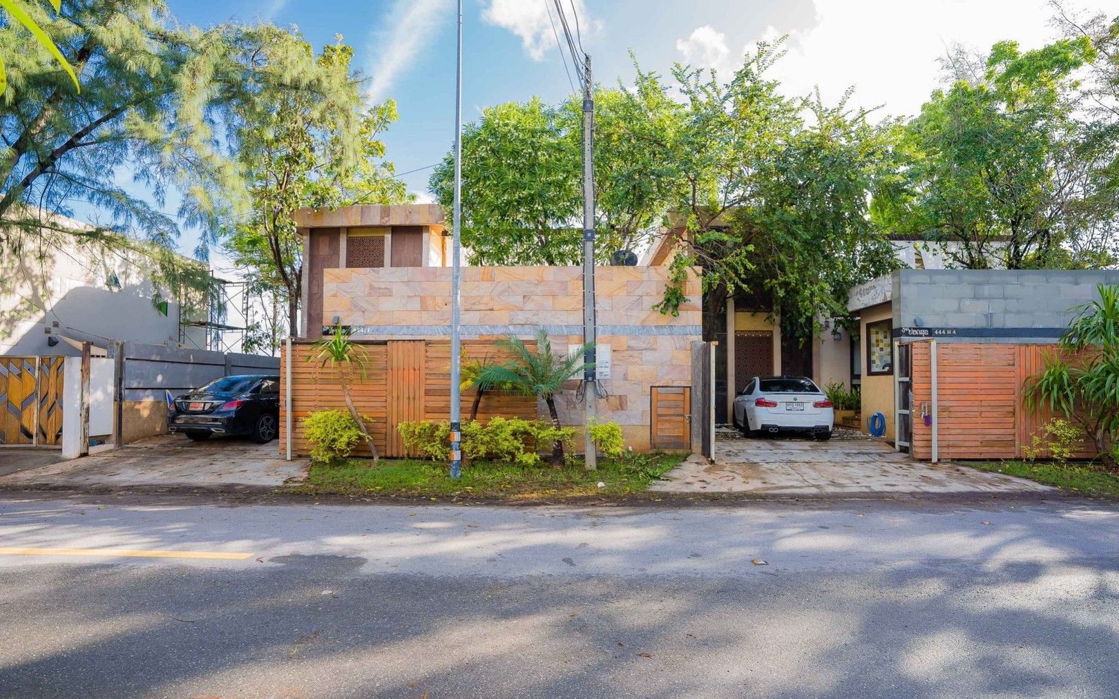 Aqua Pran II Pool Villa exterior street view in เขาสามร้อยยอด ปราณฯ, Thailand. Facade with stone and wood accents, cars parke