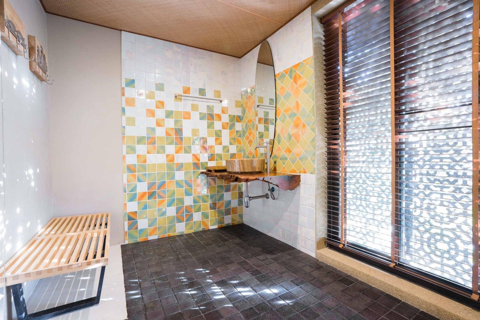 Bathroom with colorful tile and wood sink at Aqua Pran II Pool Villa, เขาสามร้อยยอด ปราณฯ. Unique design.