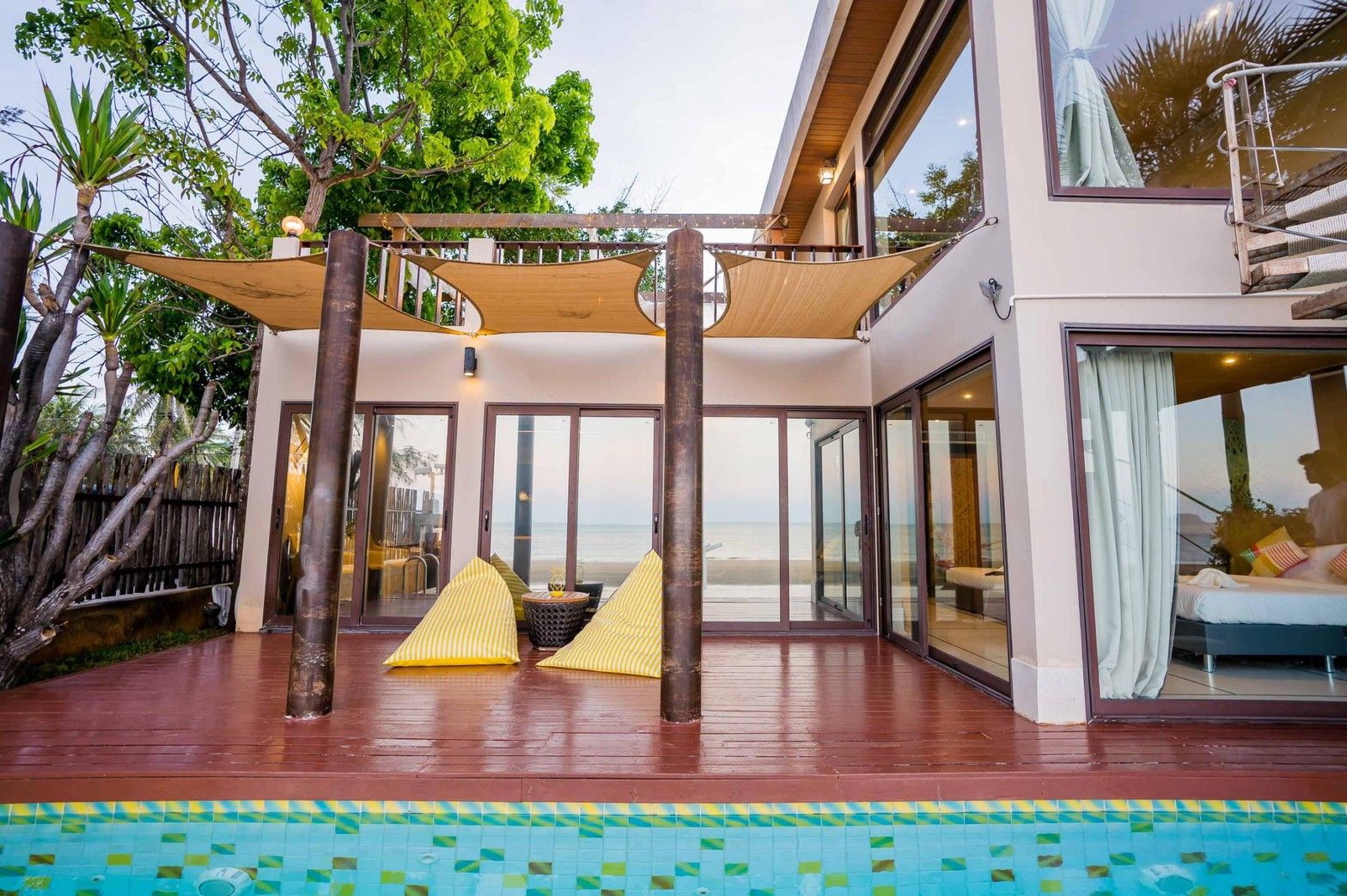 Aqua Pran II pool villa poolside deck in เขาสามร้อยยอด ปราณฯ with yellow beanbag chairs and ocean view.