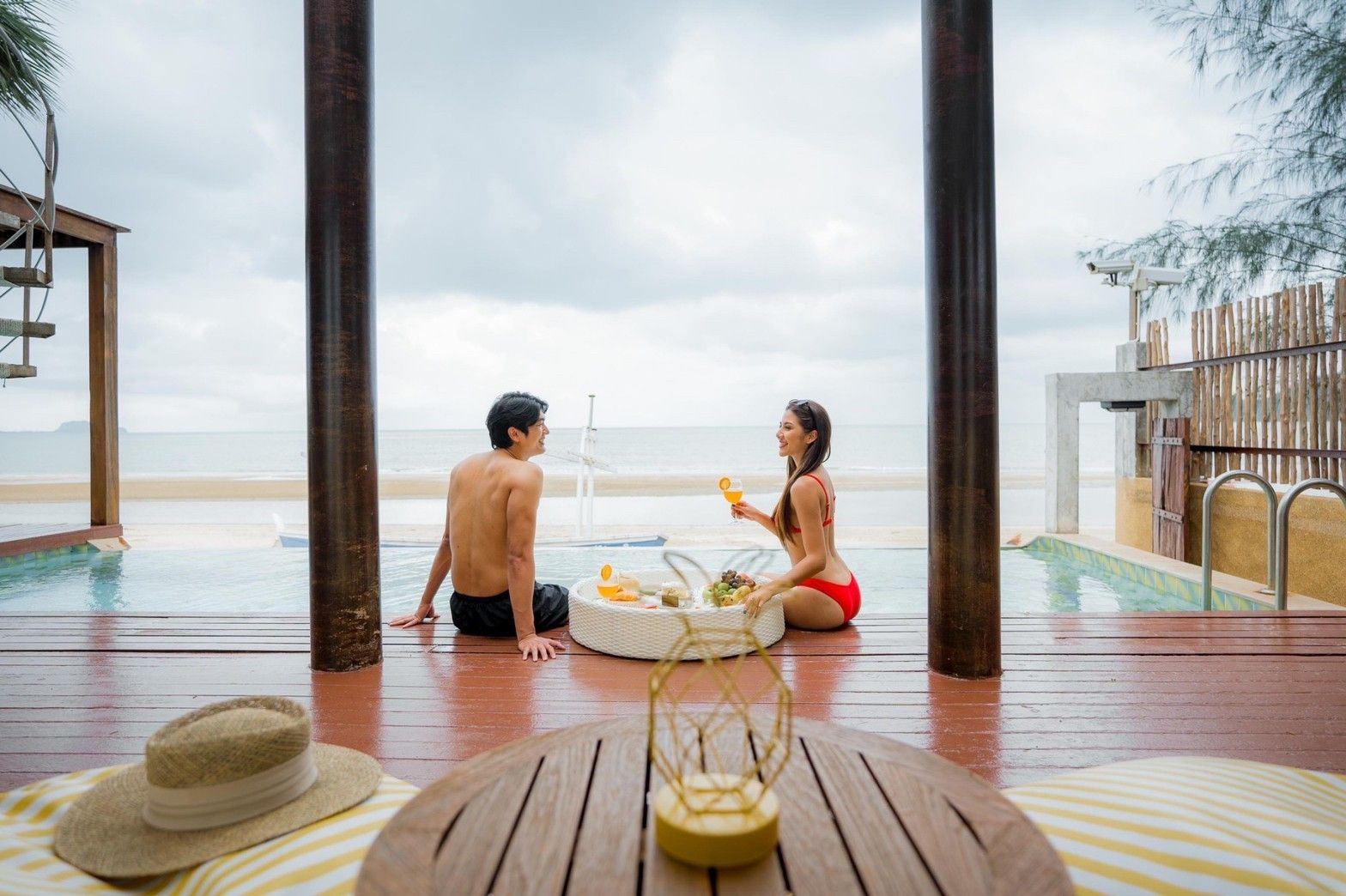 Couple enjoys breakfast by the pool at Aqua Pran II Pool Villa, เขาสามร้อยยอด ปราณฯ. Relaxing beachfront villa life.