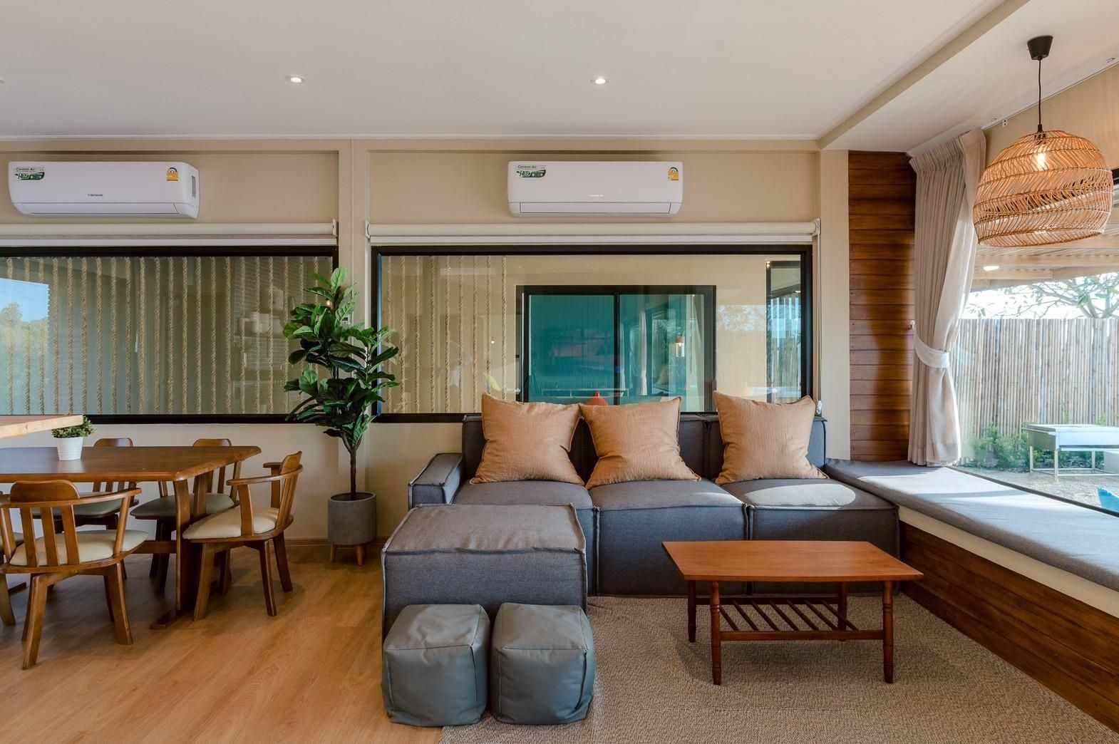 Living area with sectional sofa and window seat at Beach Blanca IV Pool Villa, Cha-Am. Modern design with natural light.