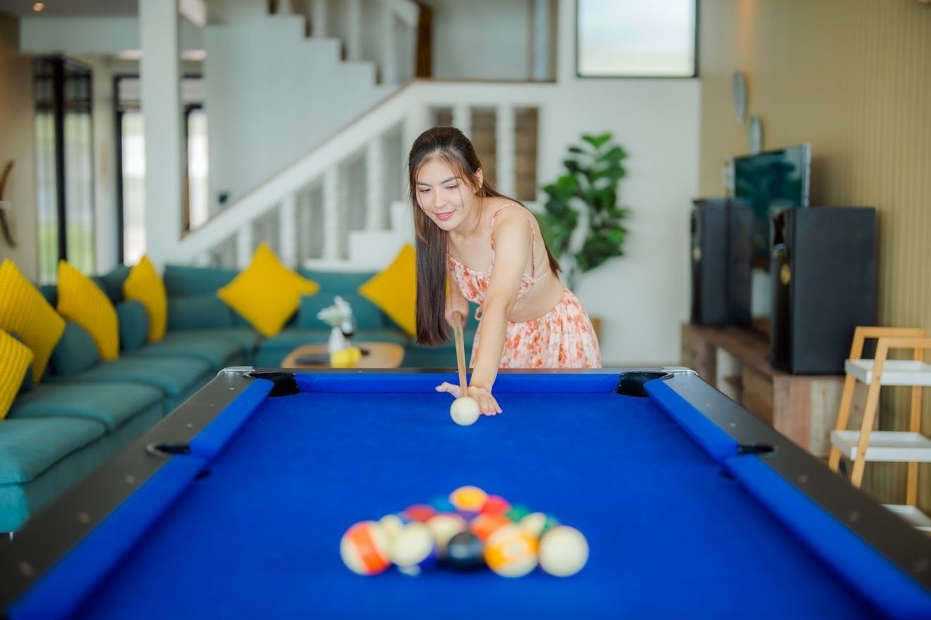 Woman playing pool at Beach Mood VI Pool Villa, Bangket Beach, Cha-am. Enjoy indoor games at this luxury villa.