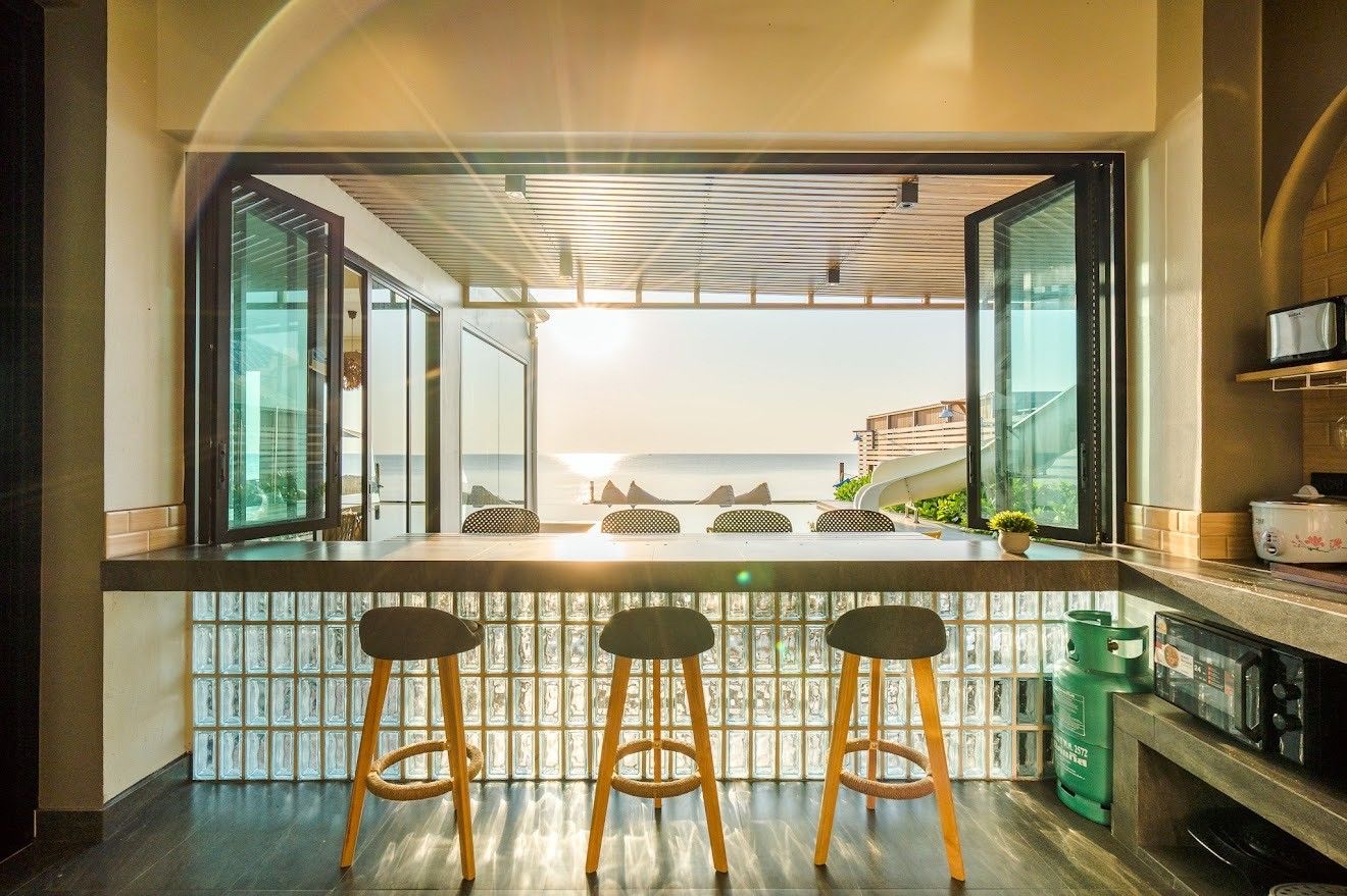 Breakfast bar with stools at Beach Mood VI Pool Villa, Cha Am. Ocean view through folding glass doors.