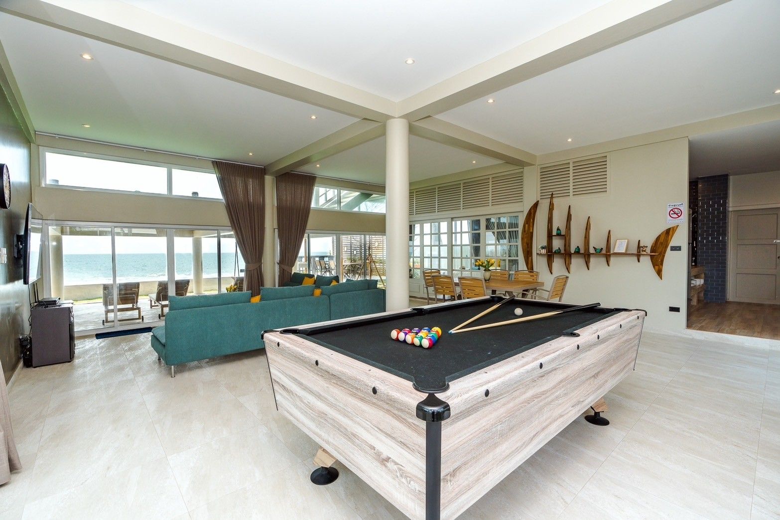 Indoor pool table at Beach Vibe-Two V Pool Villa, ติดทะเล ใกล้หาดบางเกตุ ชะอำ. View of ocean and living area.