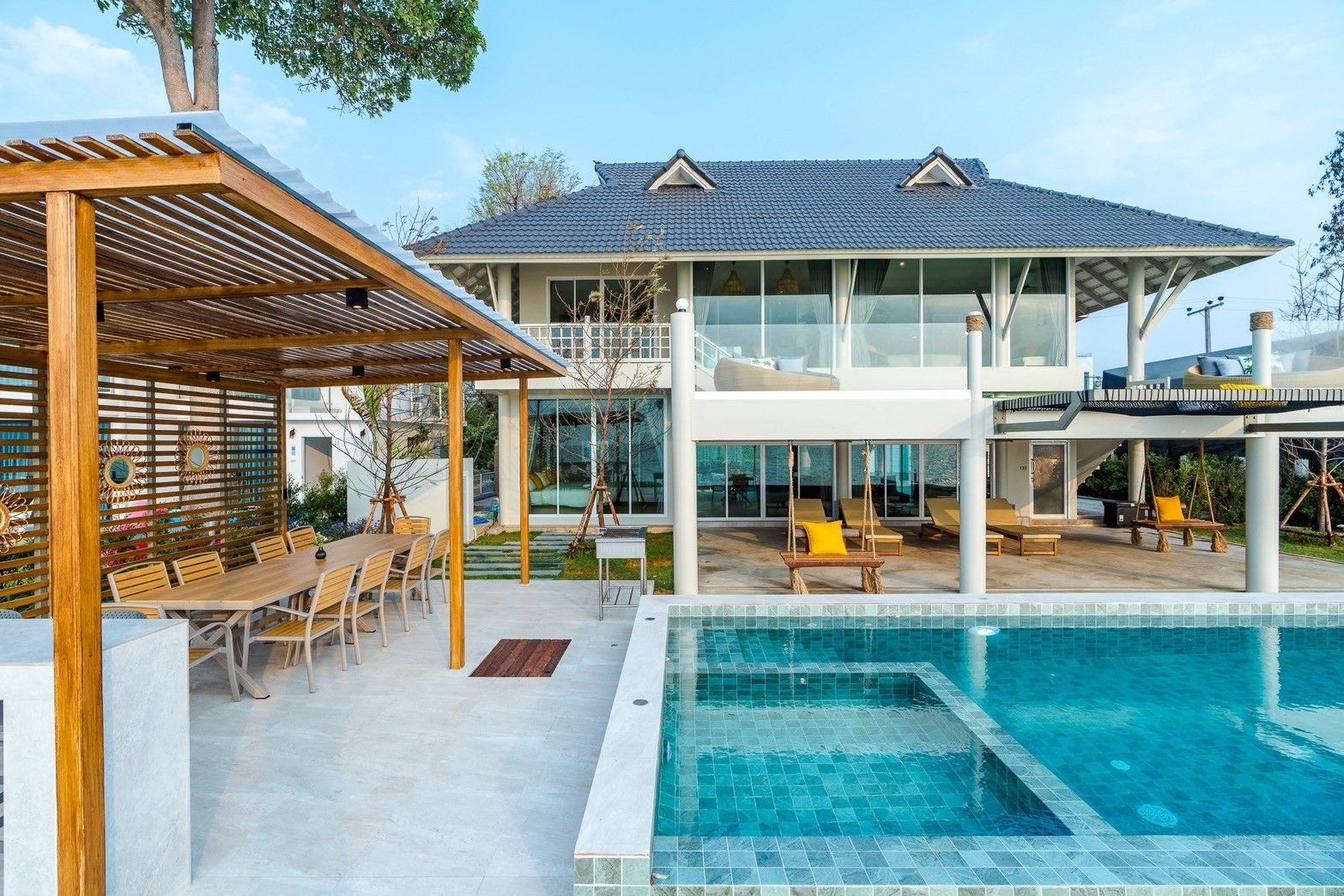 Beach Vibe-Two V Pool Villa pool and outdoor dining area in Cha Am, Thailand. View of the villa from the pool.