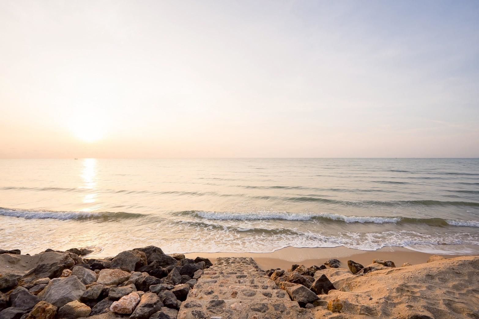 Beach access stairs at Beyond V Pool Villa, หาดปึกเตียน-ชะอำ. Stone steps lead to the sandy beach and calm ocean waves.