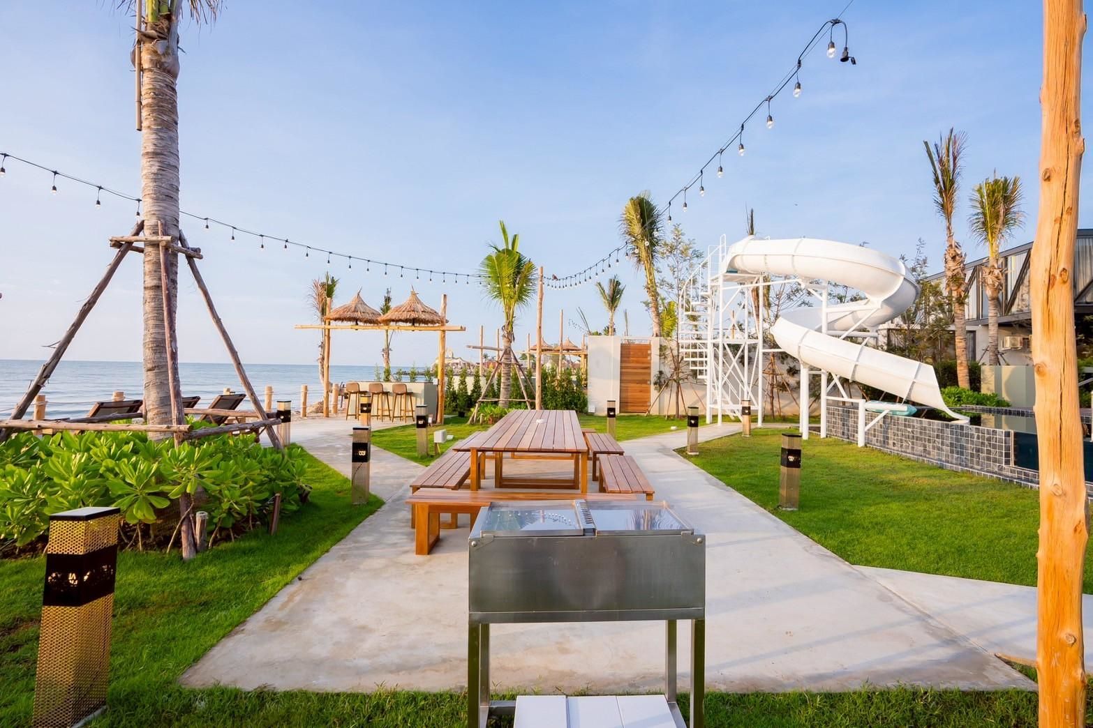 Beachfront BBQ and waterslide at Beyond V Pool Villa, หาดปึกเตียน-ชะอำ. Outdoor dining and entertainment.