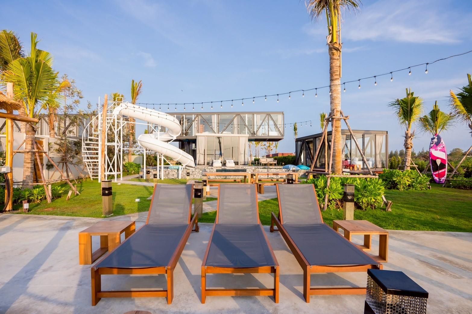 Poolside lounge chairs at Beyond V Pool Villa, หาดปึกเตียน-ชะอำ. Relax by the pool and enjoy the view.