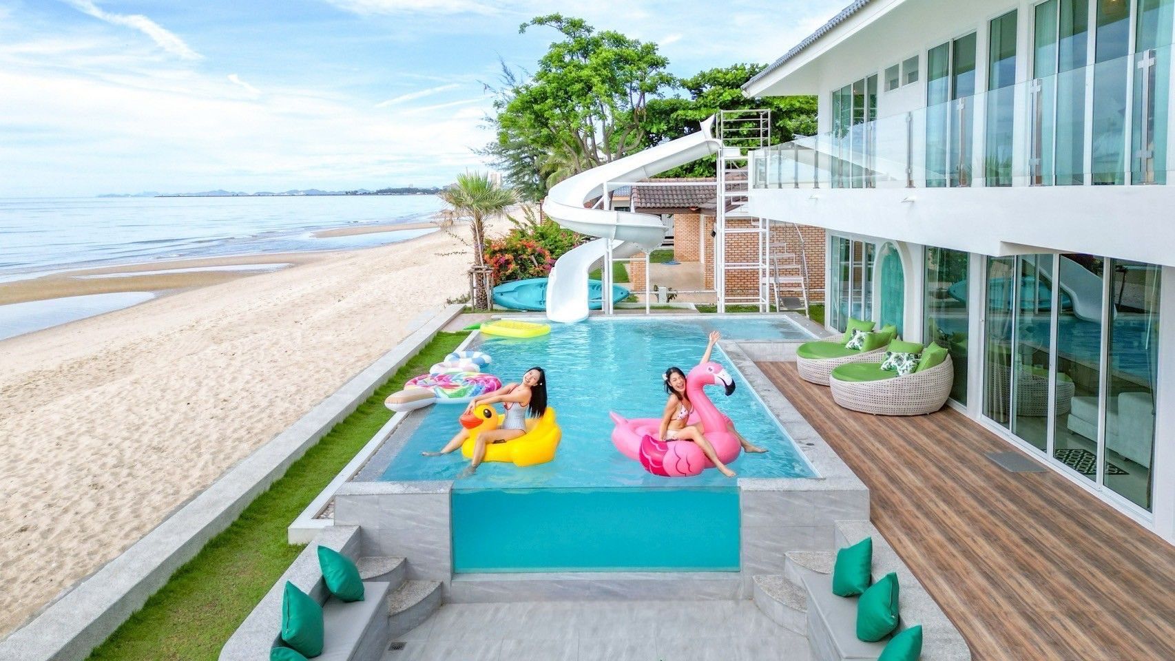 Beachfront pool with water slide and floats at Bubble Sea VII