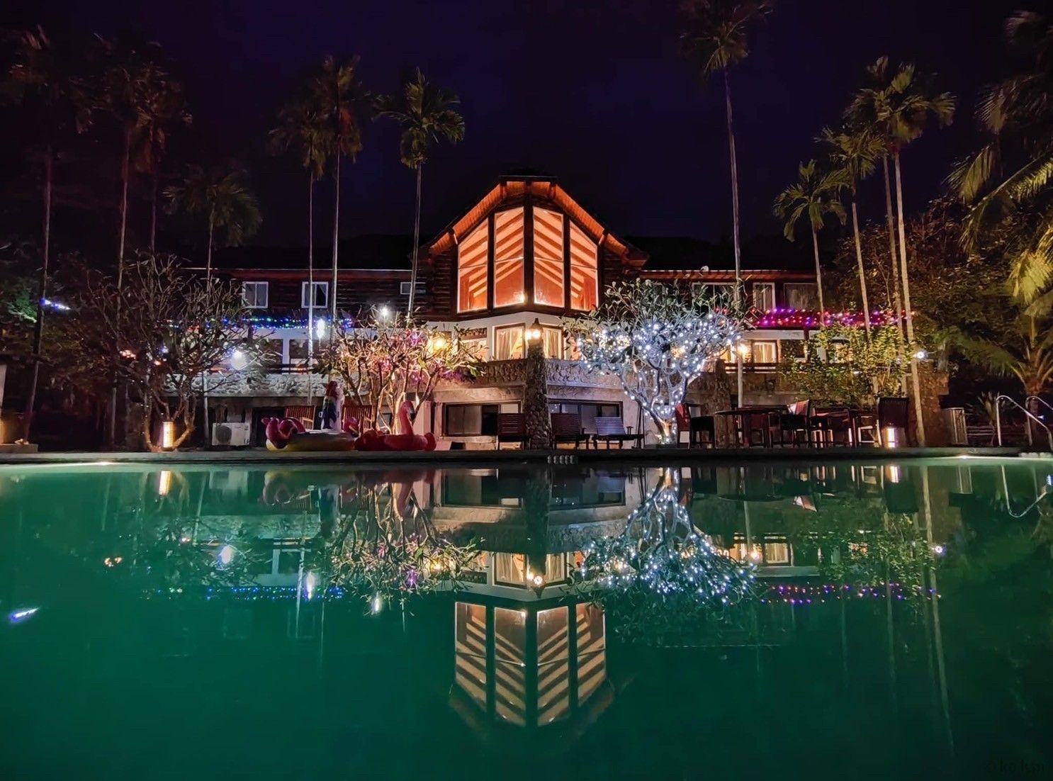 Cabin Pool Villa at night with holiday lights and pool reflection.