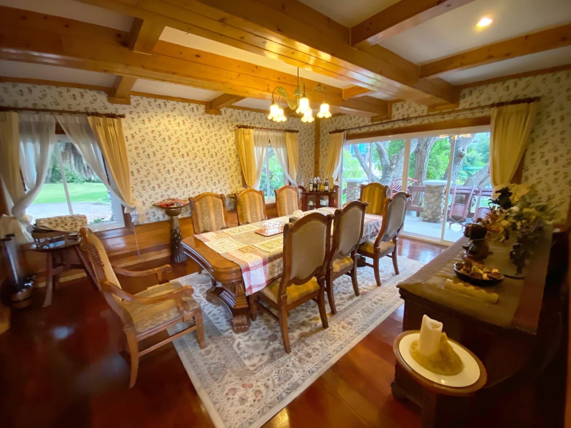Elegant wooden dining room with chandelier at Cabin Pool Villa Khao Yai.