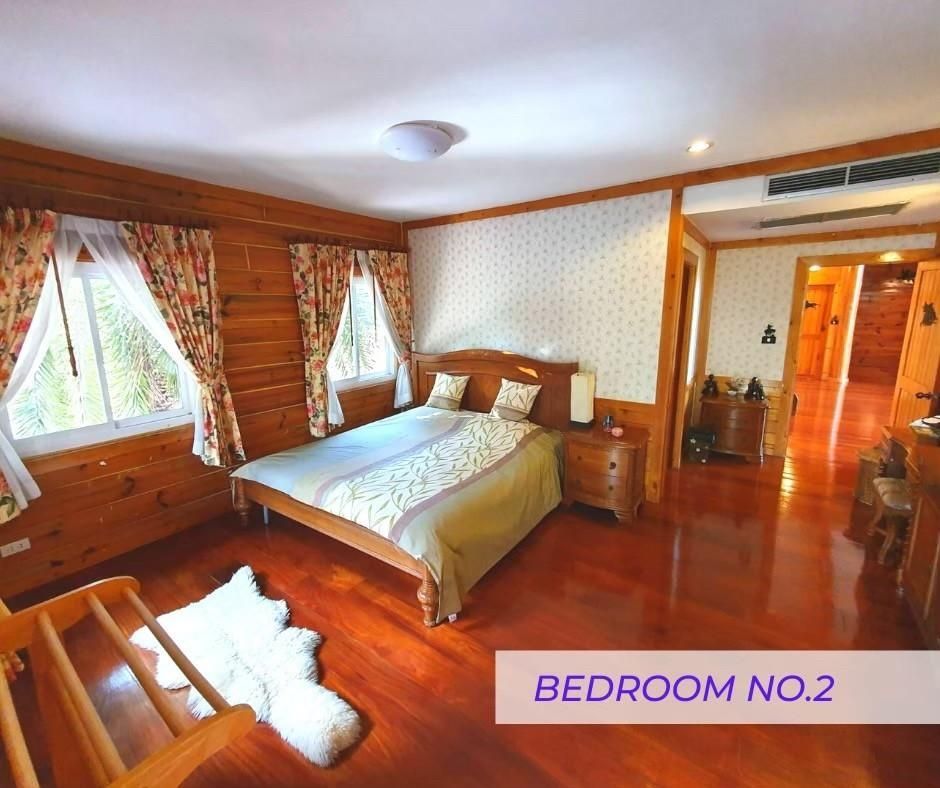 Bedroom 2 with wooden walls and classic furniture at Cabin Pool Villa Khao Yai.