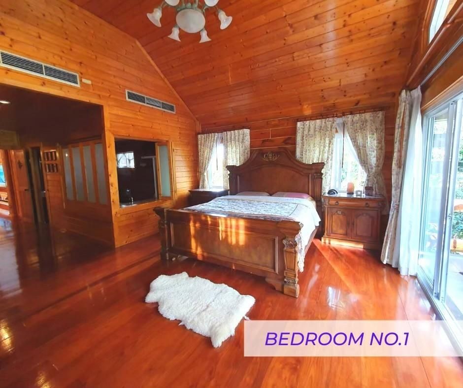 Master bedroom with vaulted wooden ceiling at Cabin Pool Villa Khao Yai.
