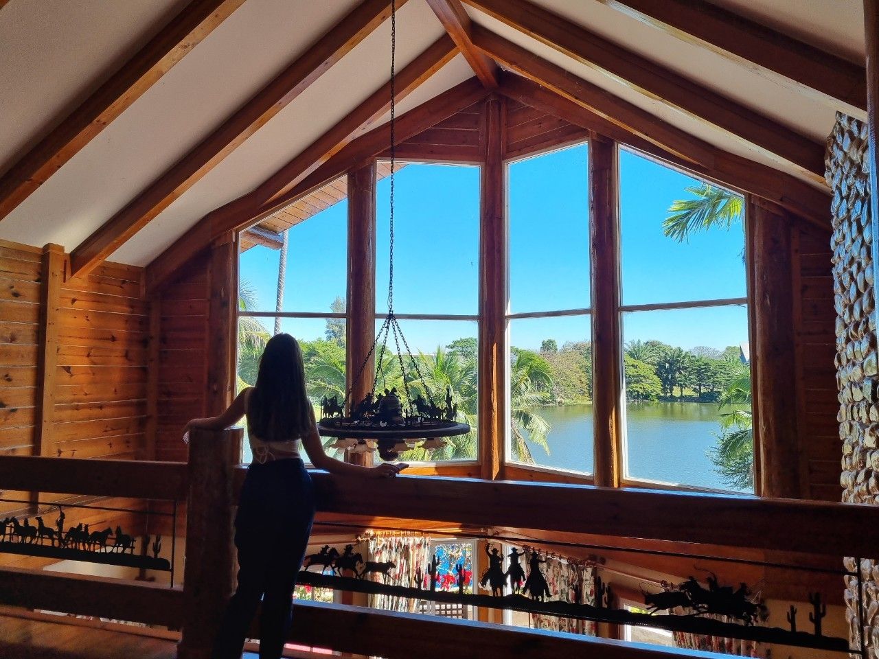 Loft area with panoramic lake view through floor-to-ceiling windows.