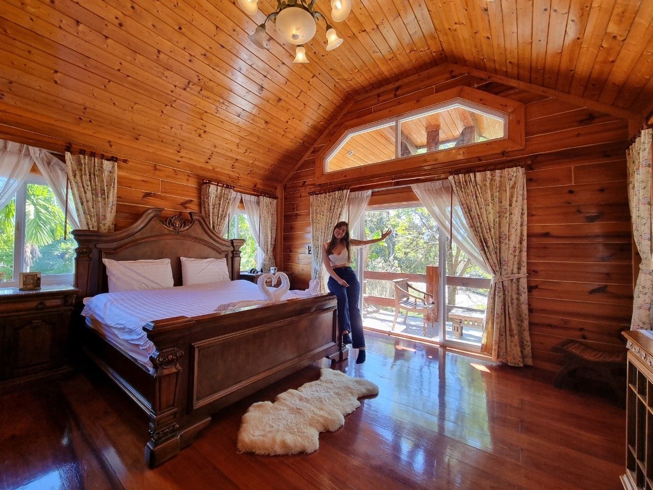 Master bedroom with vaulted ceiling and garden balcony view.
