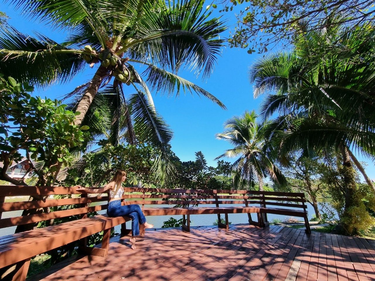 Wooden deck terrace under palm trees at Cabin Pool Villa Khao Yai.