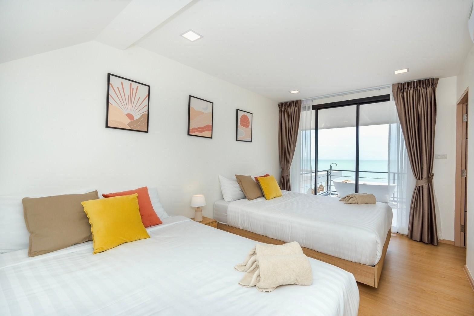 Bright bedroom with twin beds and balcony at Costa IV Beachfront Pool Villa, Cha-am, Phetchaburi. Ocean view from the balcony