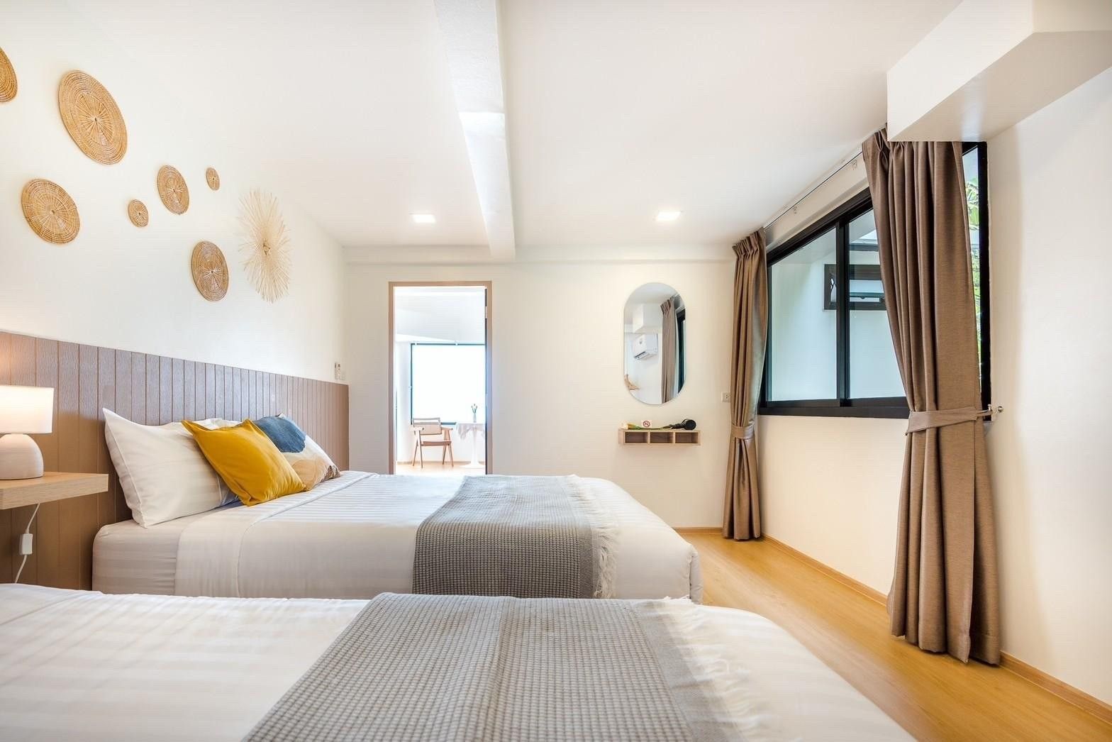 Bedroom with twin beds and window at Costa IV Beachfront Pool Villa, Cha-am Phetchaburi. Neutral decor, light wood floors.