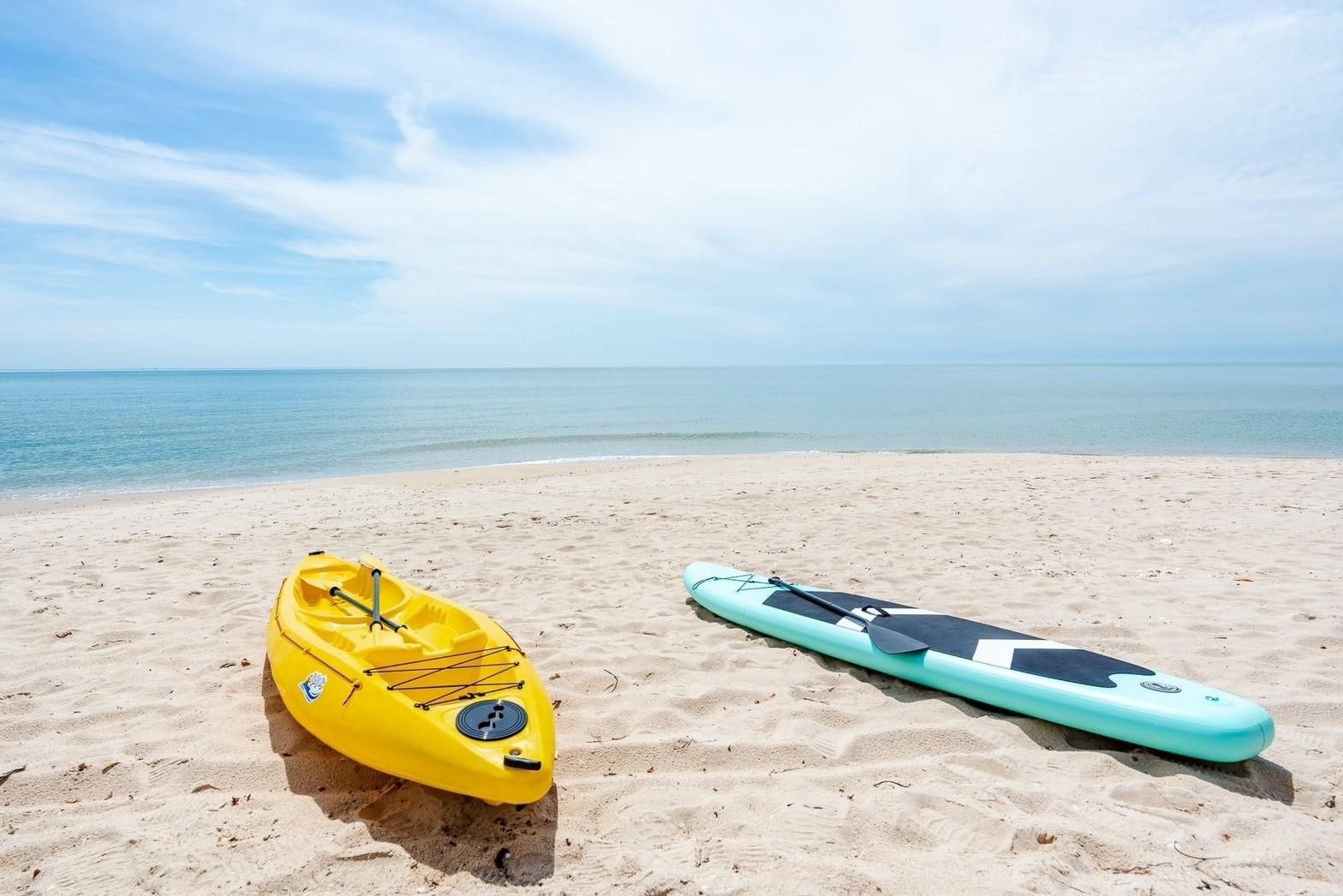Yellow kayak and paddle board on the beach at Costa IV Beachfront Pool Villa, ชะอำ เพชรบุรี. Water sports equipment.