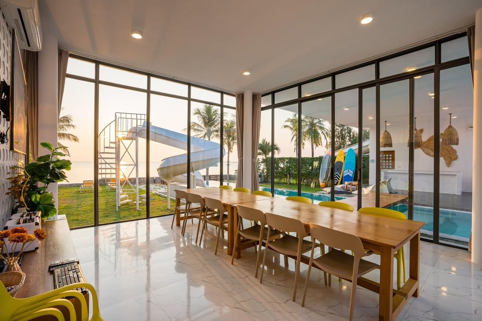 Dining table with pool view and water slide at Cross Sea VII Pool Villa, หาดคลองเทียน-ชะอำ. Seats 10.