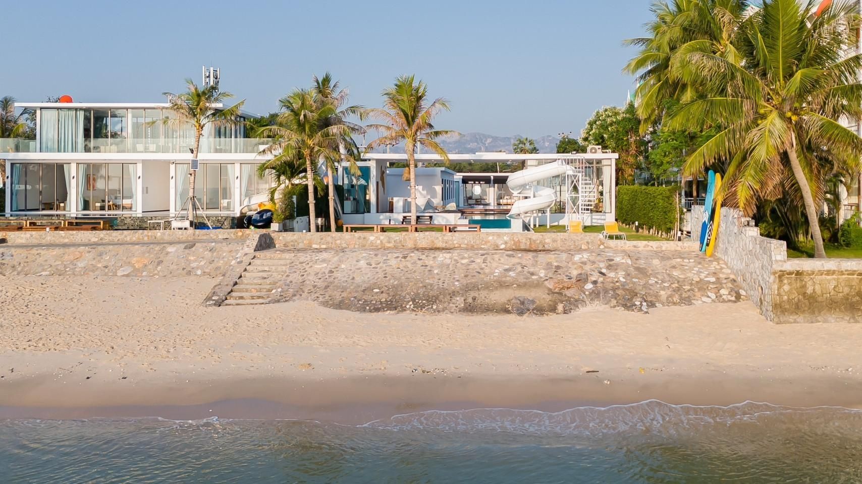 Cross Sea VII Pool Villa beachfront view from the ocean in หาดคลองเทียน-ชะอำ. Modern villa with water slide and palm trees.
