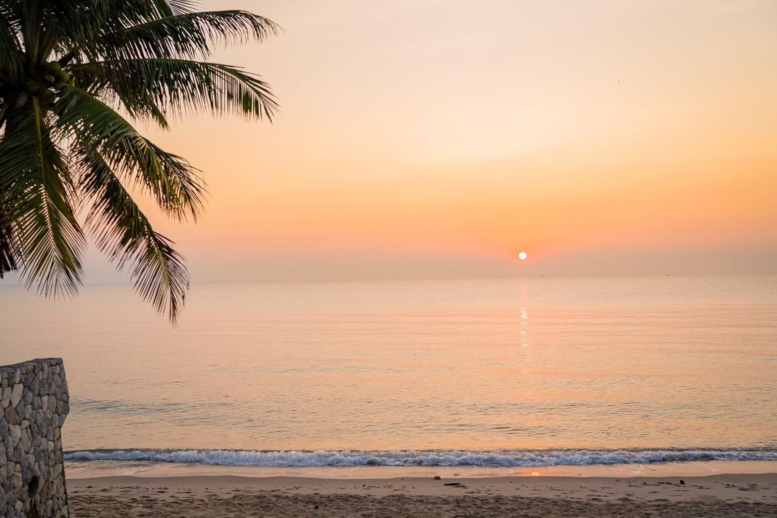 Sunrise view from Cross Sea VII Pool Villa, หาดคลองเทียน-ชะอำ. Palm tree, beach, and ocean visible.