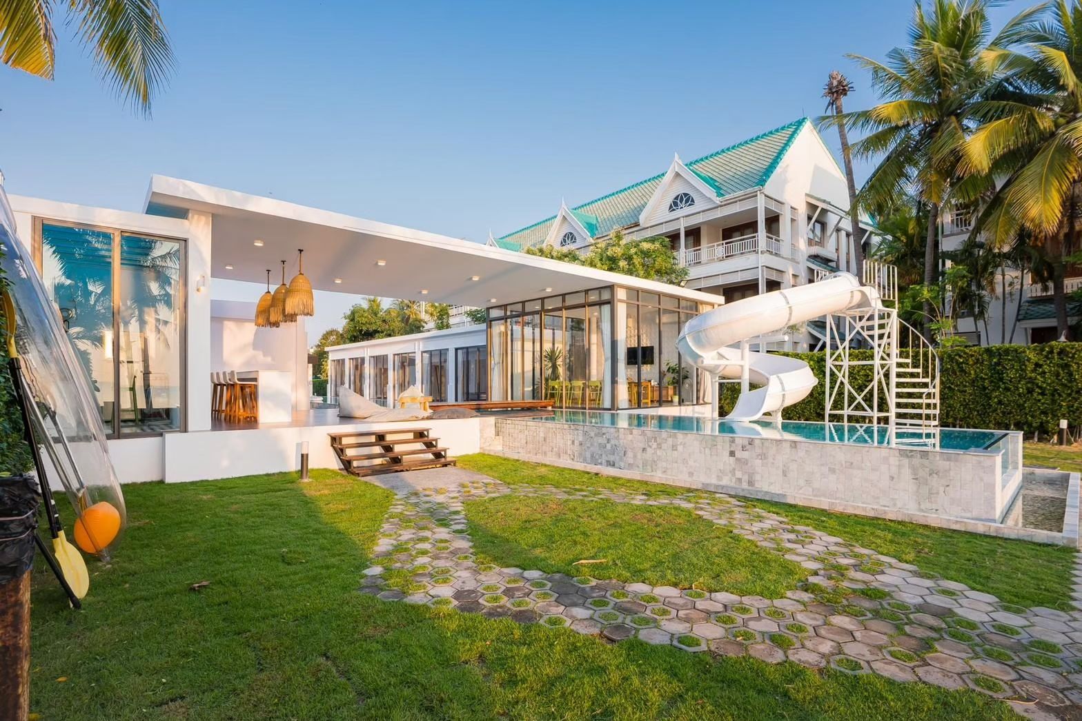 Cross Sea VII pool villa, หาดคลองเทียน-ชะอำ, features a water slide into the pool. Modern design with outdoor bar area.