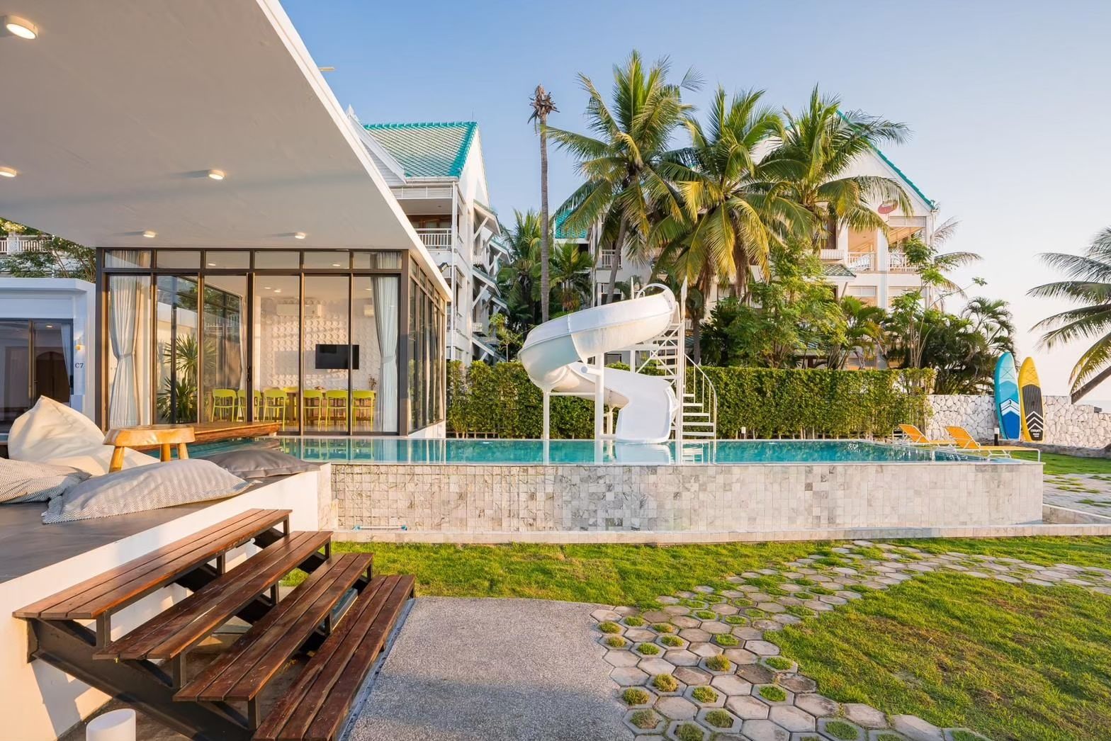 Cross Sea VII Pool Villa pool with water slide, หาดคลองเทียน-ชะอำ. View of the slide, pool, and outdoor dining area.