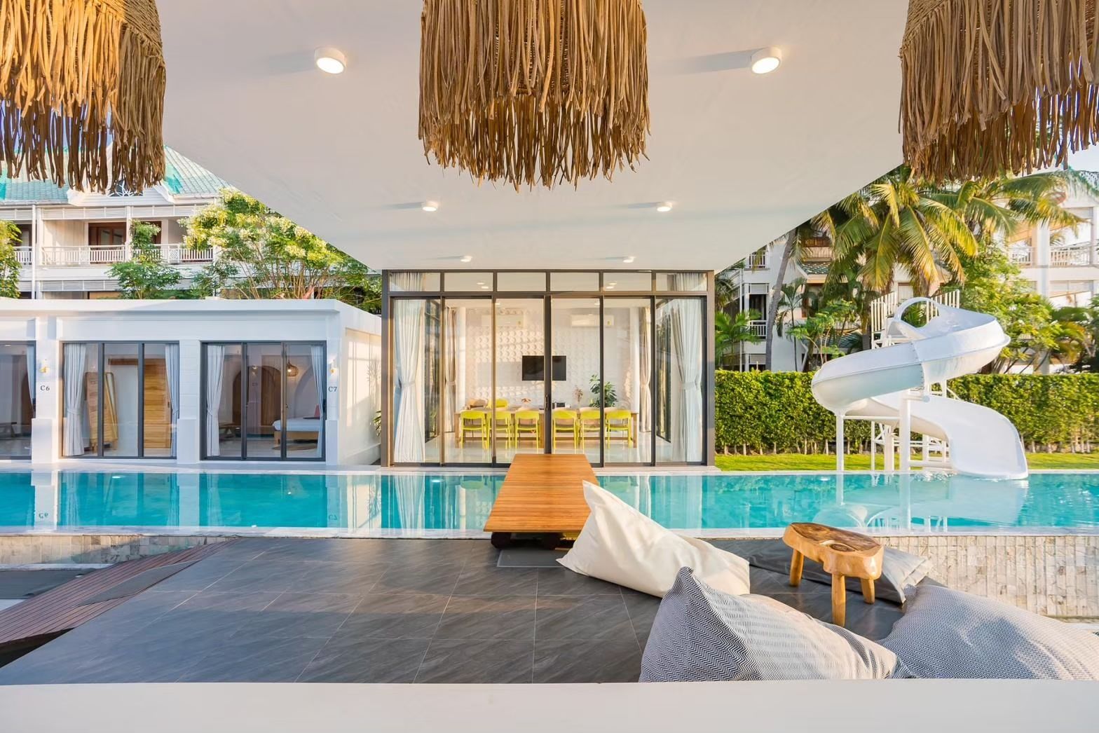 Cross Sea VII pool villa, หาดคลองเทียน-ชะอำ. View of the pool with waterslide, beanbag chairs, and dining room.