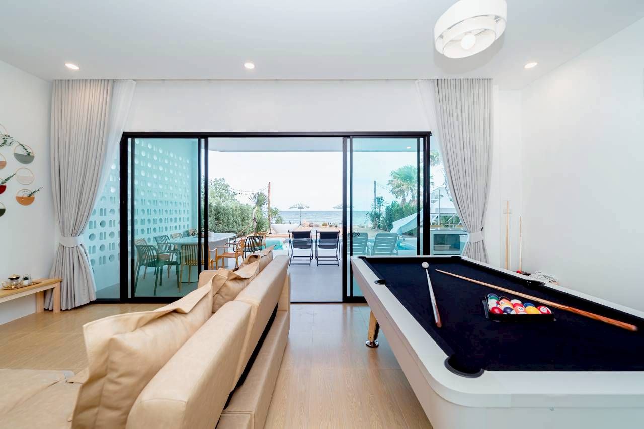 Darlington IV pool villa entertainment: indoor pool table with view to outdoor pool and beach.