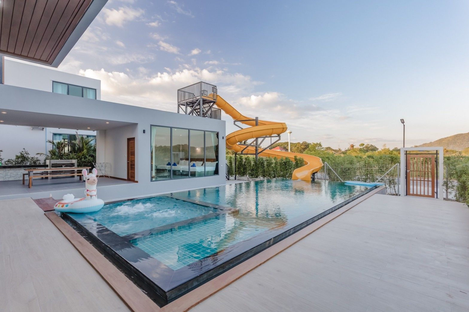 Exclusive Proud VII Villa Hua Hin pool with waterslide and jacuzzi. Inflatable llama floatie on deck.