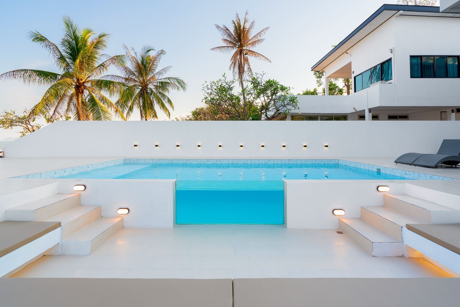 G Villa III pool villa in Pak Nam Pran, Pranburi. View of the pool with glass panel and steps leading down.
