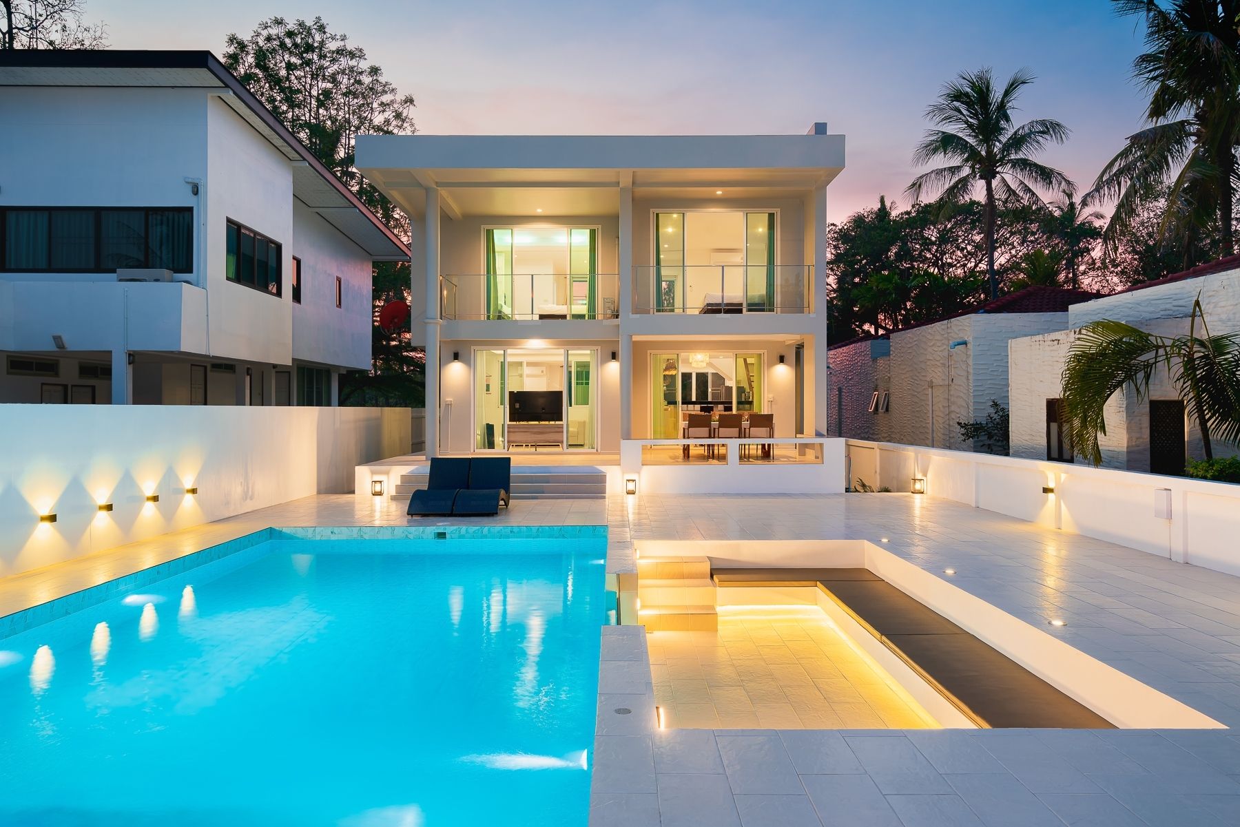 G Villa III pool villa in Pak Nam Pran, Pranburi. View of the pool and sunken seating area at dusk.