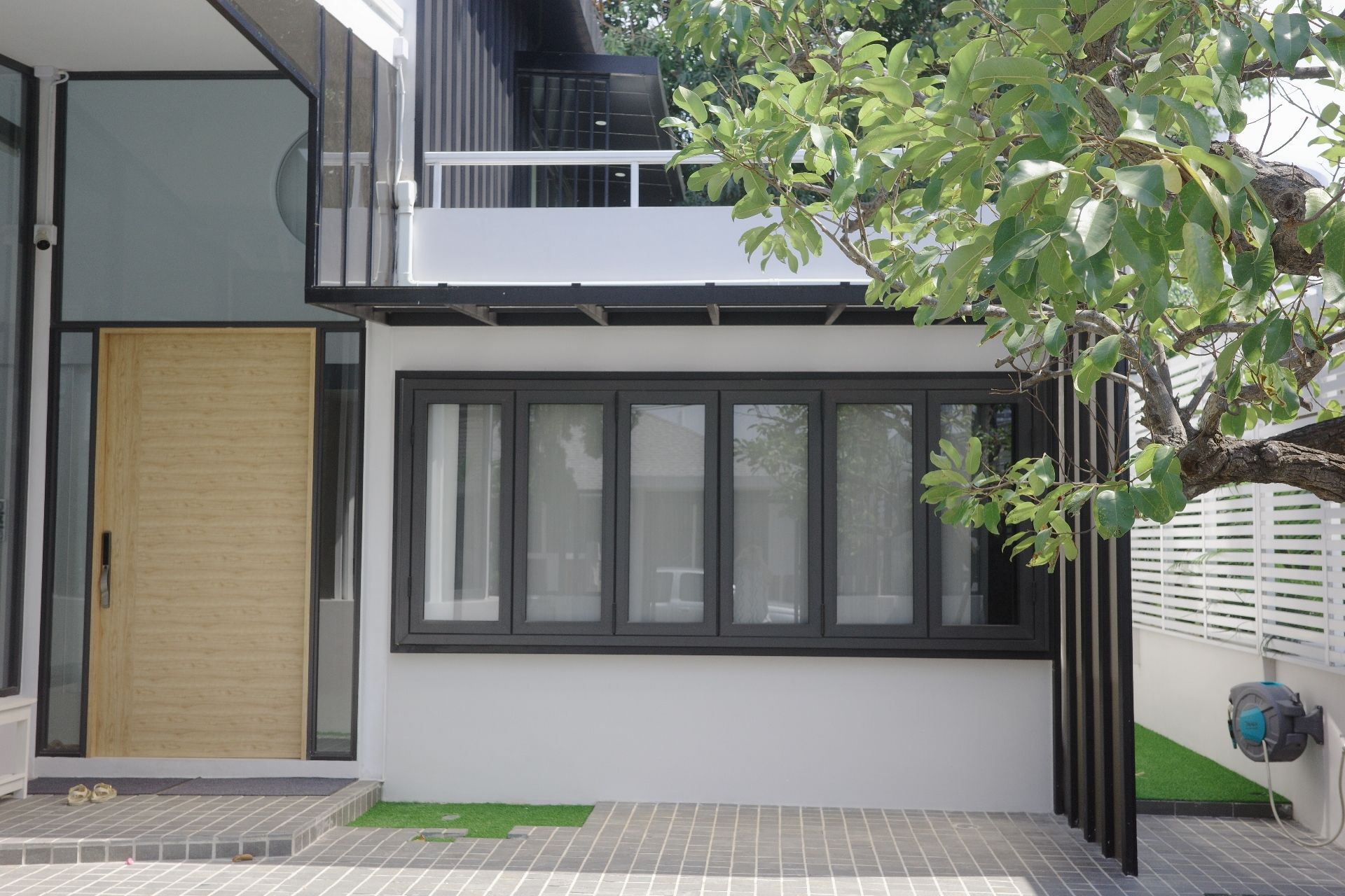 Glass Beach III Pool Villa exterior in หาดดงตาล พัทยาใต้ features a modern facade with large windows and a wooden door.