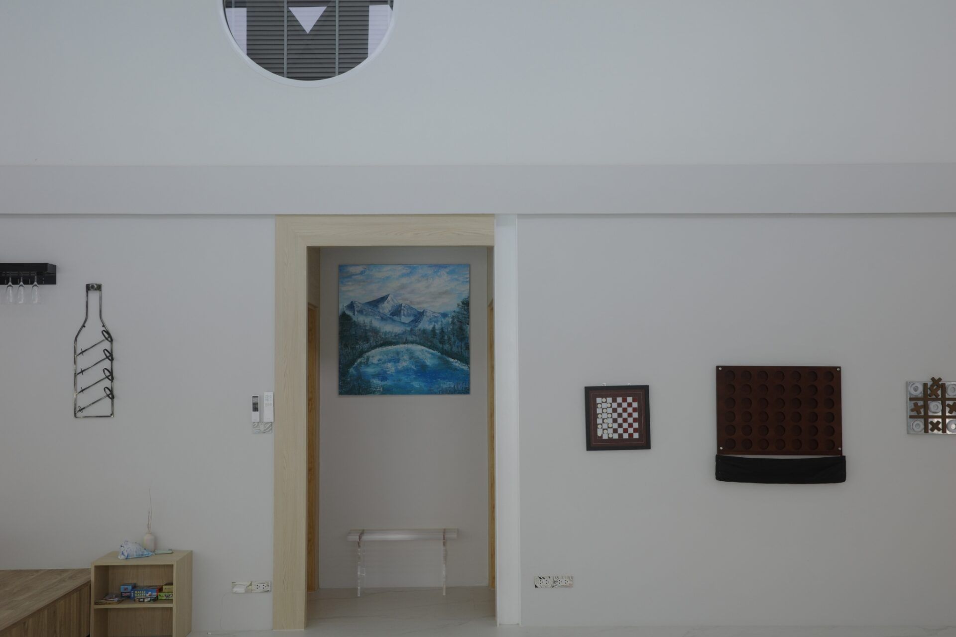 Wall art and games in Glass Beach III Pool Villa, หาดดงตาล พัทยาใต้. Checkers, tic-tac-toe, and wine rack.