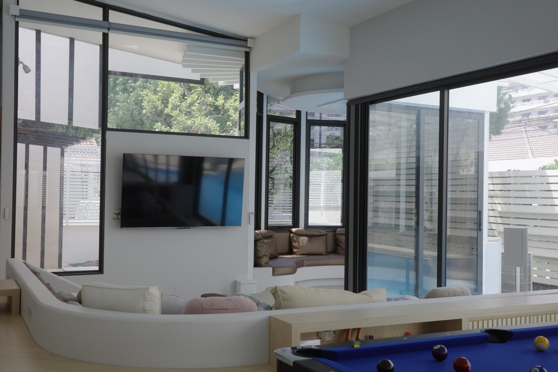 Living room with curved sofa and pool view at Glass Beach III Pool Villa, Dongtan Beach, South Pattaya.