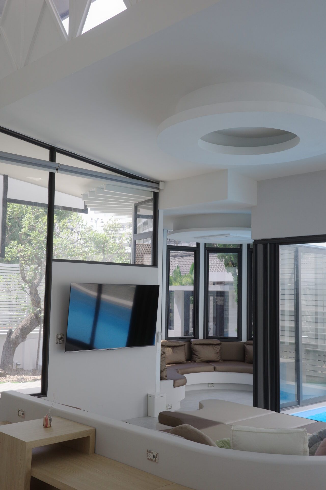 Modern living room with sunken seating area at Glass Beach III Pool Villa, หาดดงตาล พัทยาใต้. Large windows and TV.