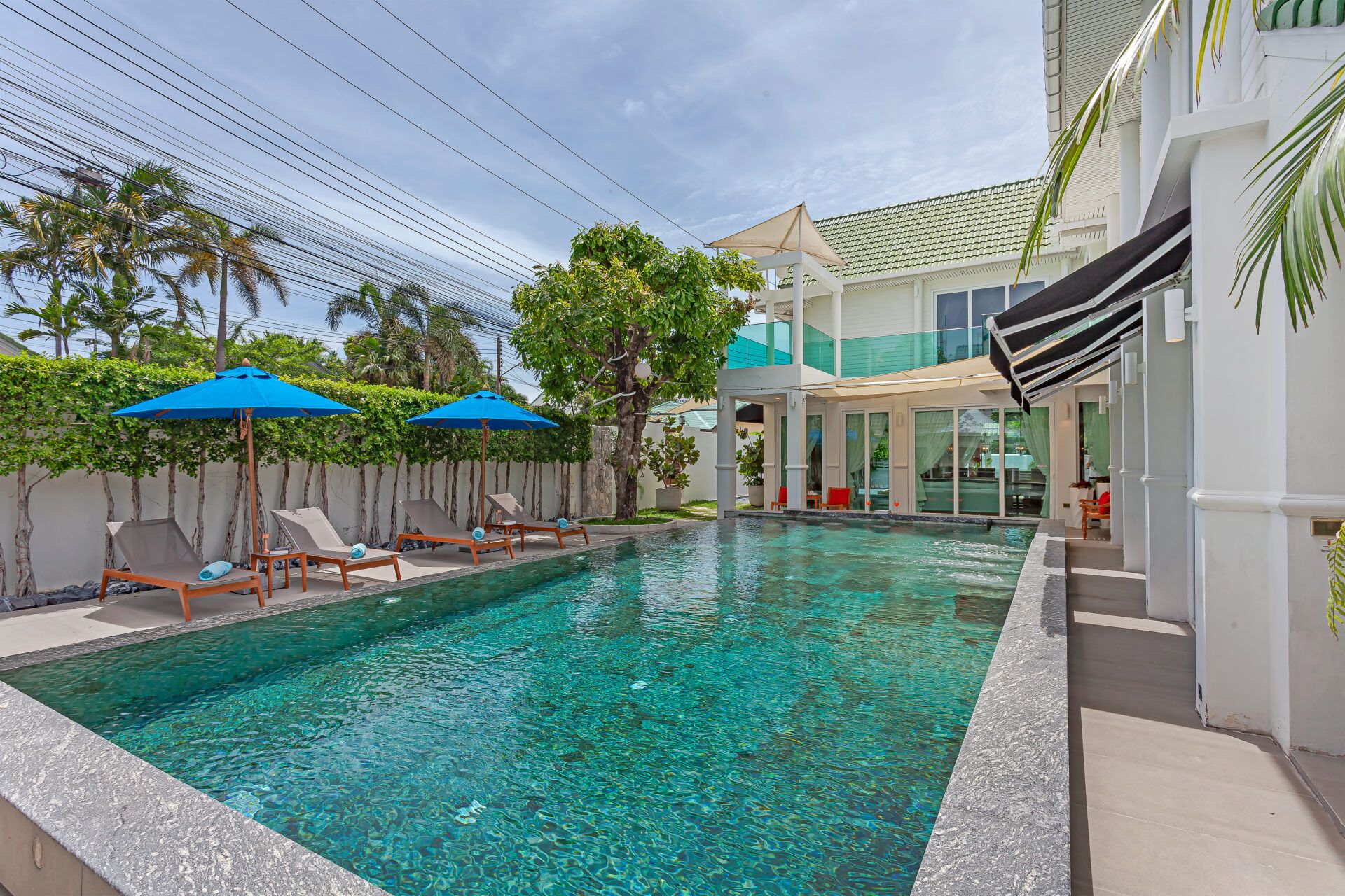 Turquoise pool and lounge chairs at HI Classic Pool Villa V, 4km from the beach in Central Pattaya.