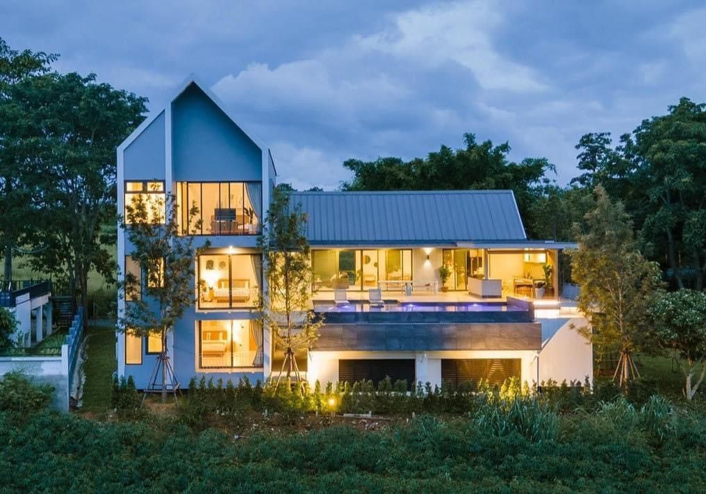 Exterior view of Kin Khaoyai V Pool Villa at dusk. Modern architecture with large windows and illuminated pool area. หมูสี เข
