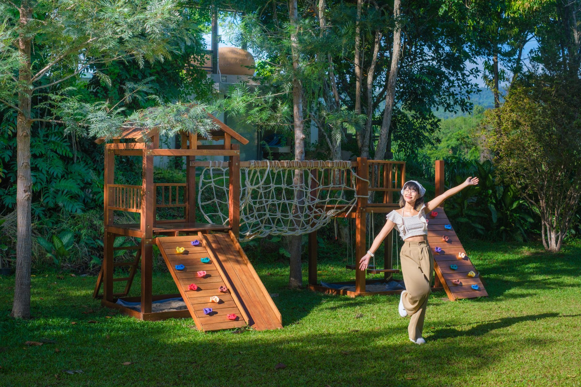 Wooden play structure with climbing wall and net at Kin Khaoyai V Pool Villa, หมูสี เขาใหญ่. Fun outdoor activity.
