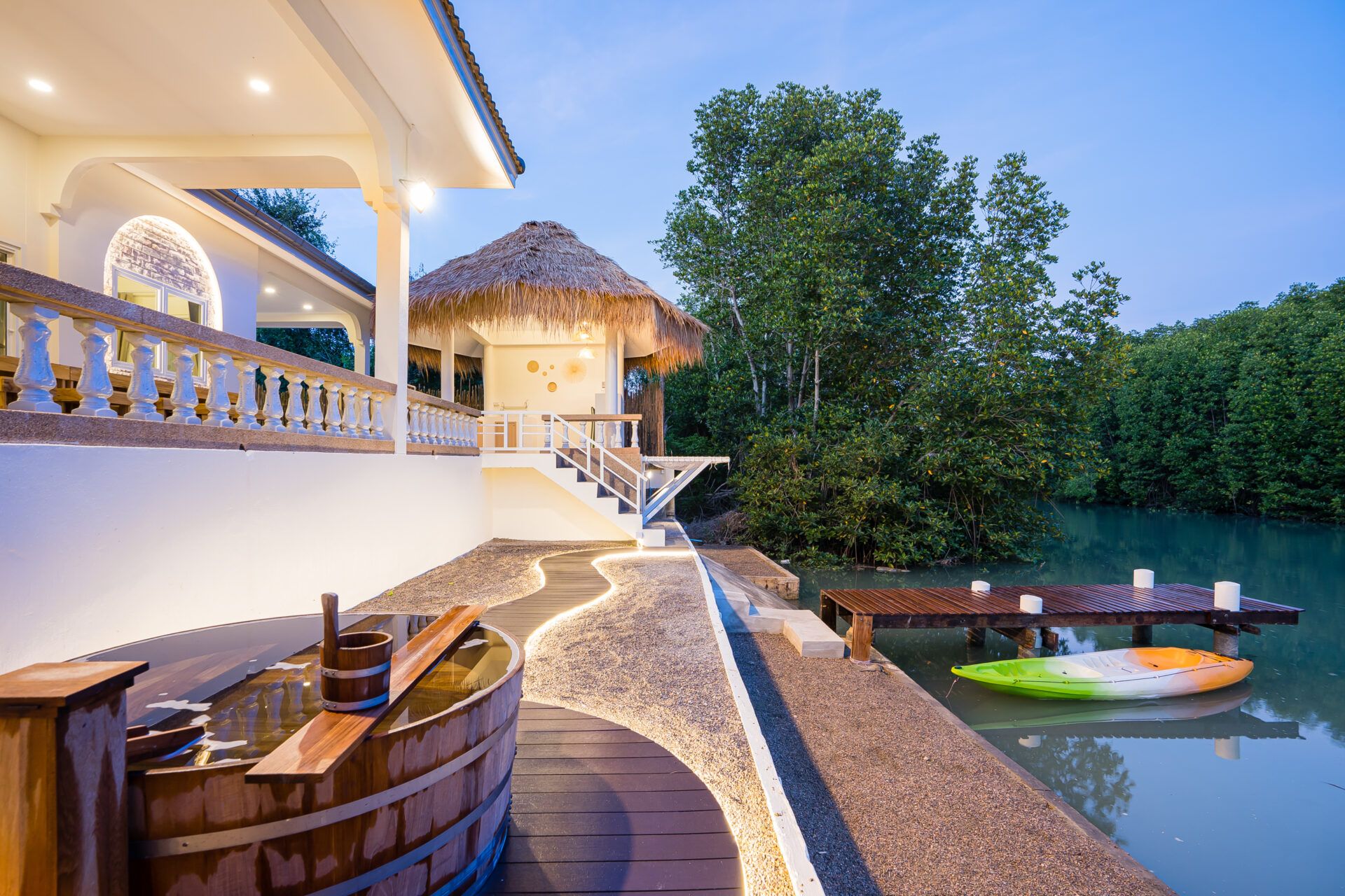 Lagoon Beach V Pool Villa exterior view with wooden hot tub, dock, and kayak near Bang Kao Beach, Cha-am.