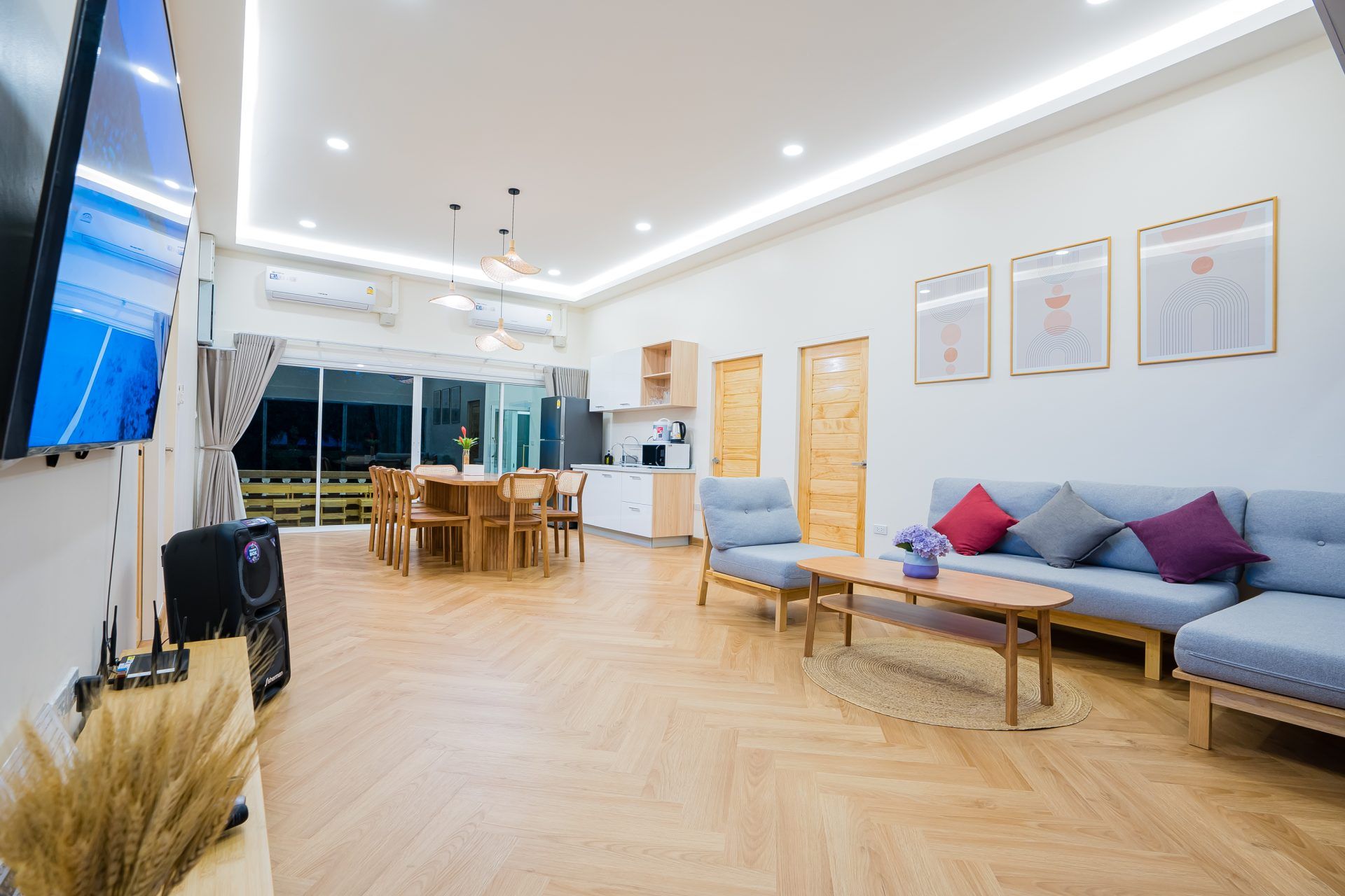 Open-plan living and dining area at Lagoon Beach V Pool Villa, ใกล้หาดบางเก่า-ชะอำ. Features sofa, dining table, and kitchen.