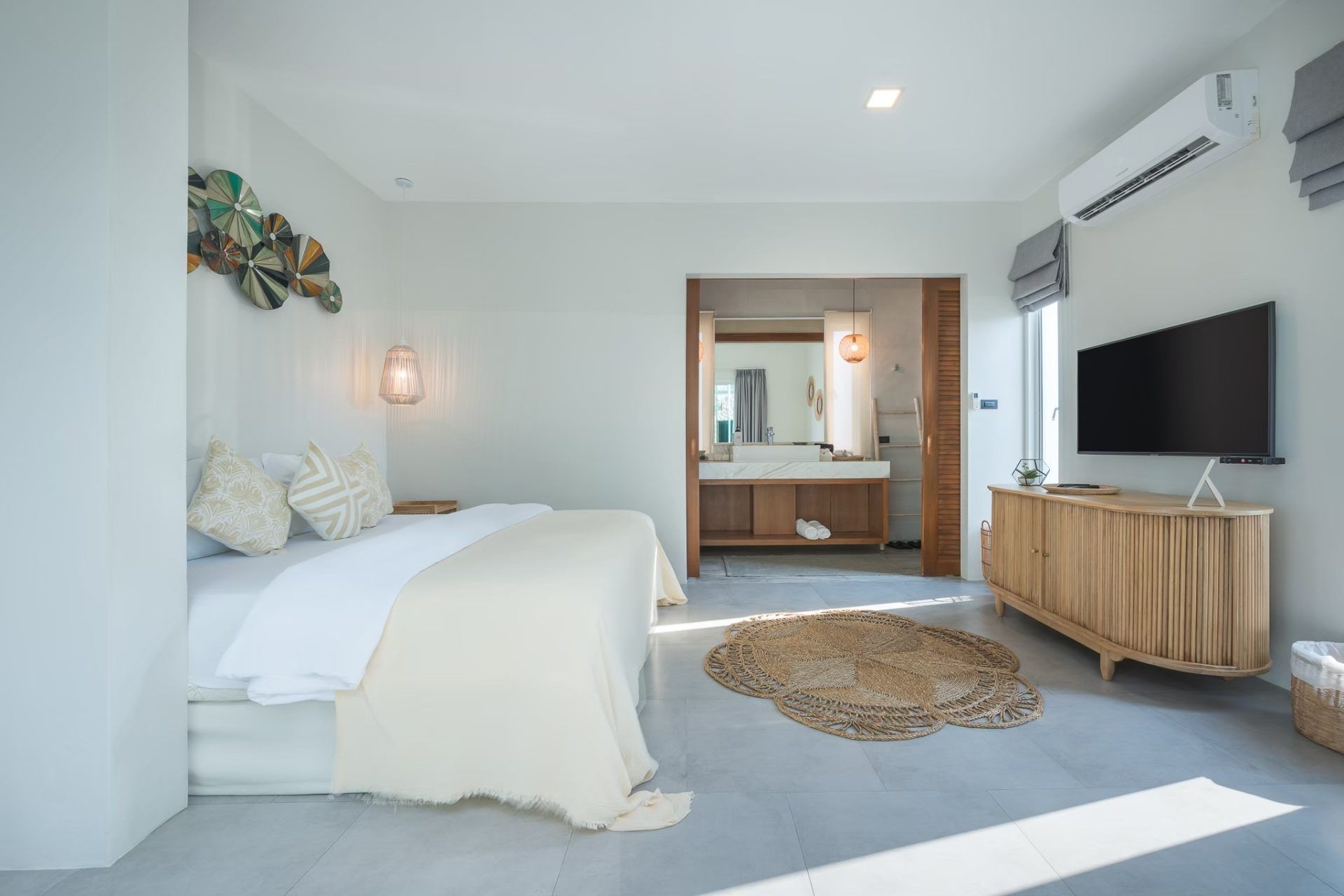 Vela VI pool villa bedroom in หาดปึกเตียน ชะอำ features a king bed, TV, and ensuite bathroom with vanity.
