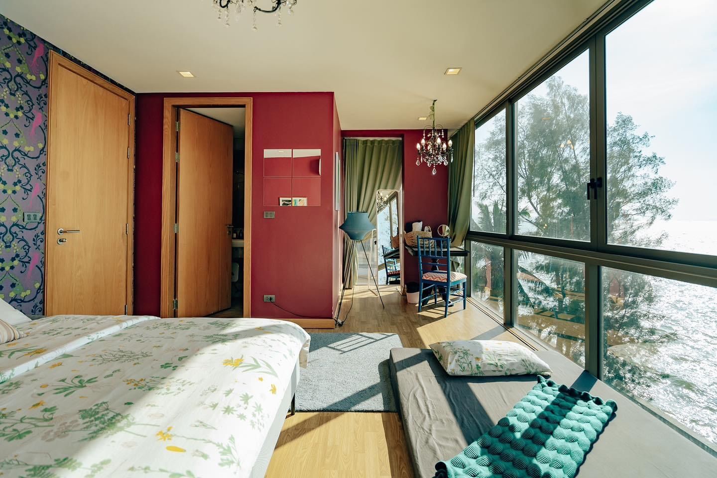 Bright bedroom with ocean view at Pink Sand Beachfront Villa, บางละมุง พัทยาเหนือ. Features daybed, desk, and large windows.